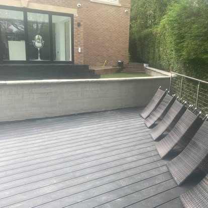 Composite decking and glass balustrade against a brick extension