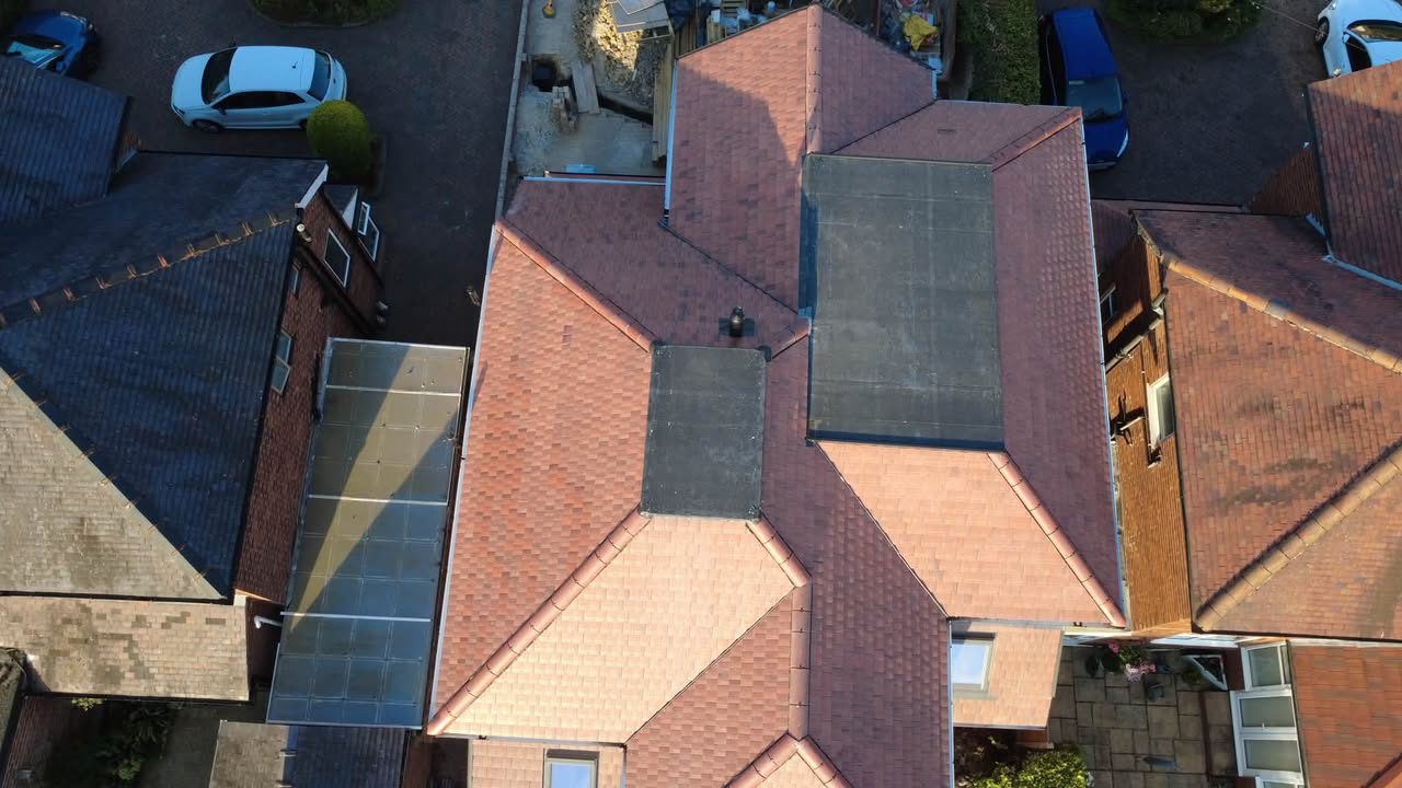 Top-down drone view of residential rooftops surveyed by JPN Building Contractors, showing tiled roofs and roof windows in detail