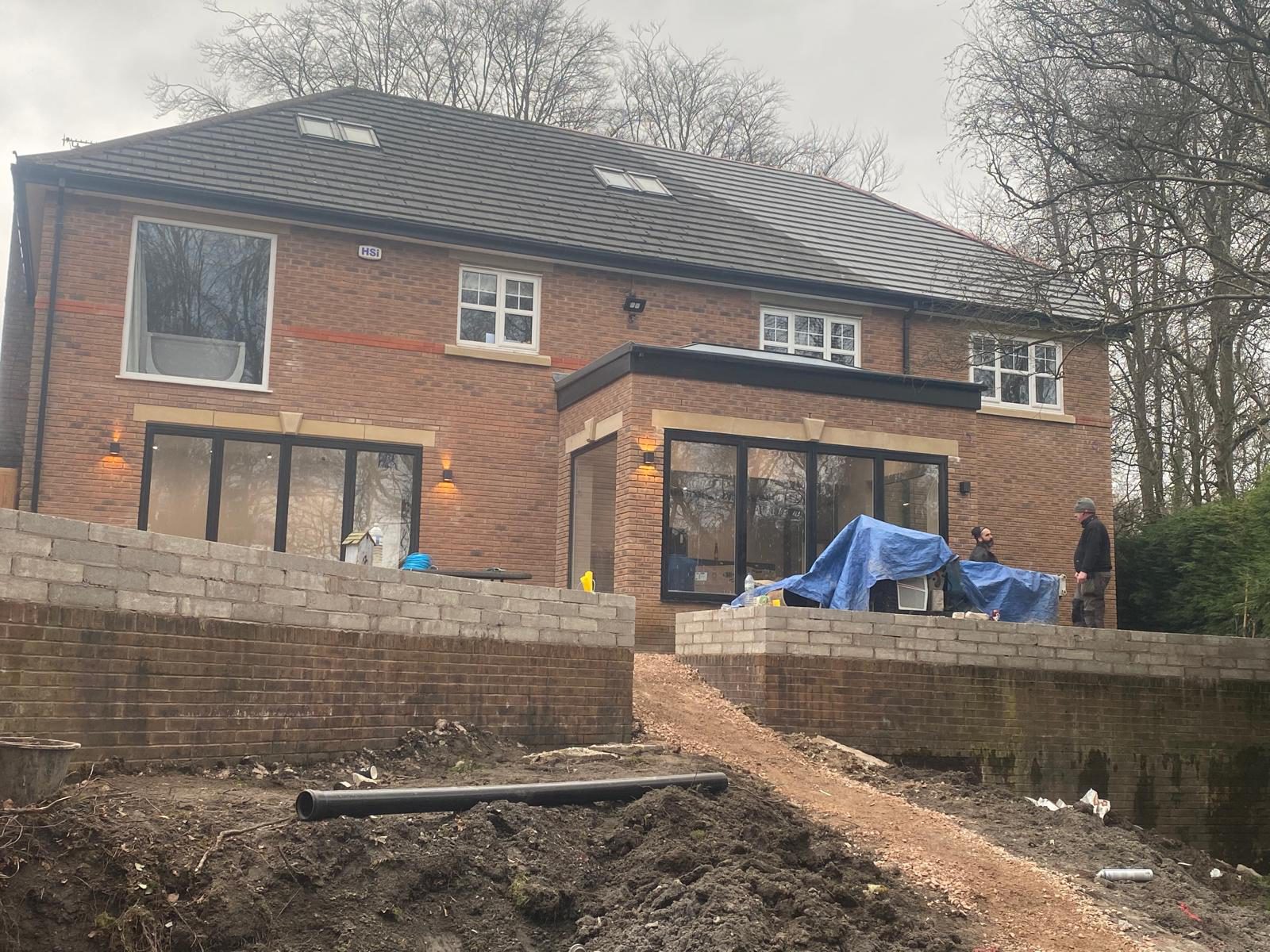 Large near-finished house extension at dusk with the JPN Builders team on site