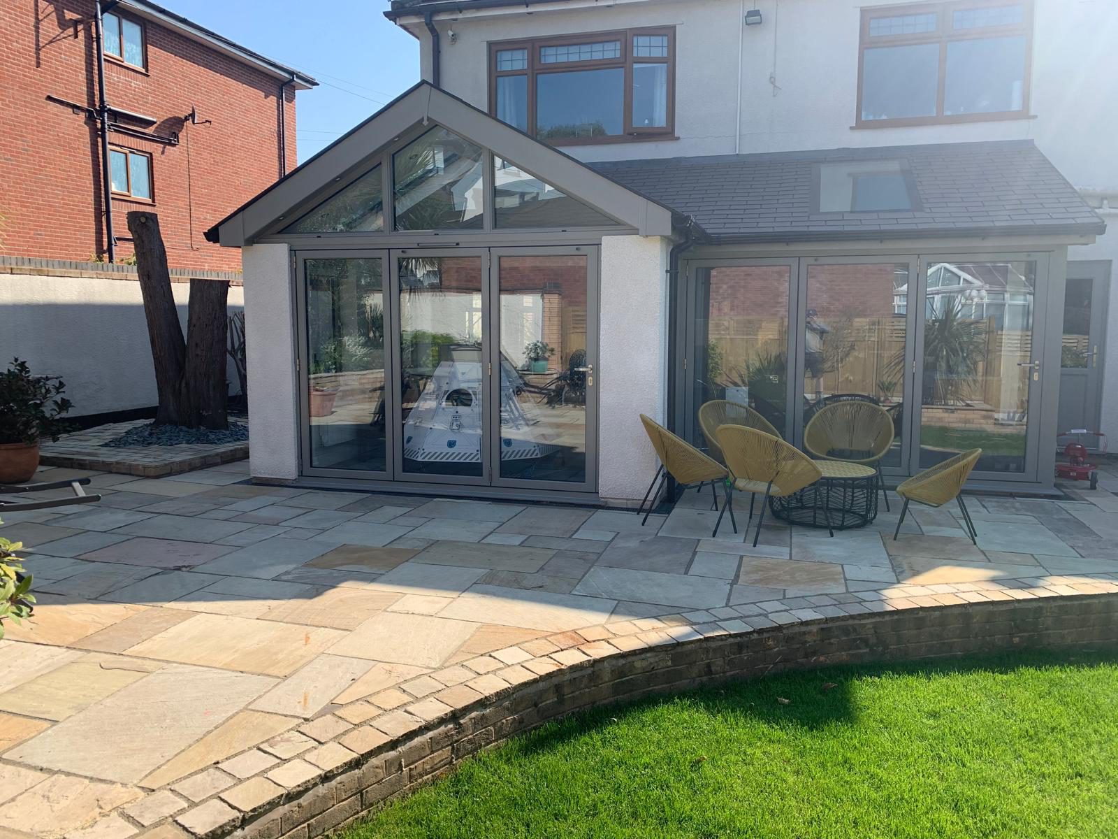 Finished gable-end glazed extension with rendered walls and a new patio