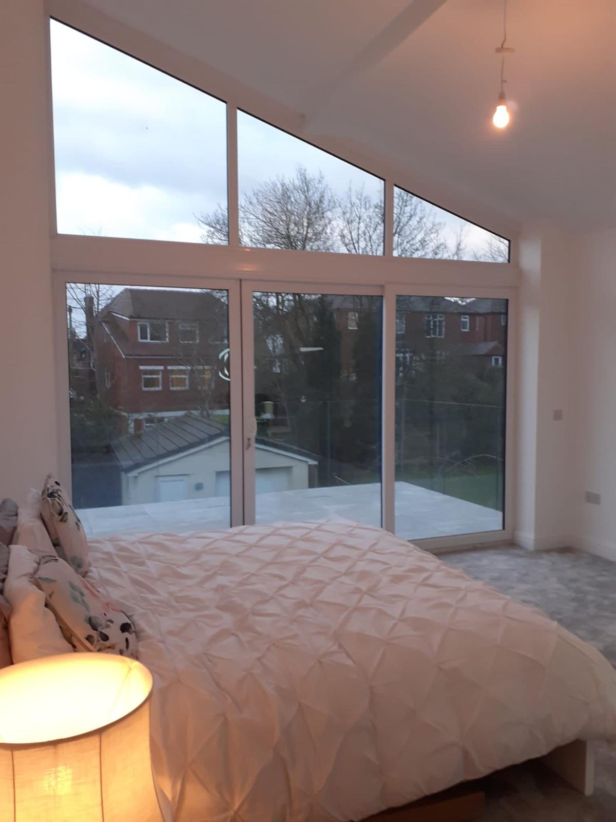 Finished bedroom extension interior with full-height vaulted glazing